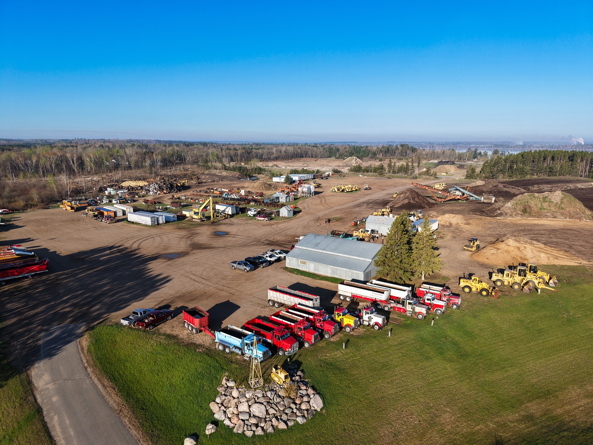 Storlie red dump trucks and wheel loaders lined up at the yard